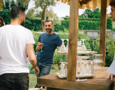 Pot de départ retraite - Les 6 bonnes raisons de choisir un traiteur pour un pot de départ en retraite - Image représentant deux jeunes hommes, dont l'un tenant un verre à la main, profitant d'un moment agréable